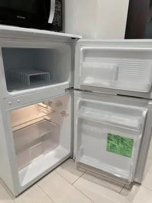 an empty refrigerator with its door open in a kitchen at Worldtraveler Roppongi in Tokyo