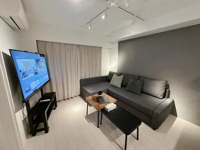 a living room with a couch and a flat screen tv at Worldtraveler Roppongi in Tokyo