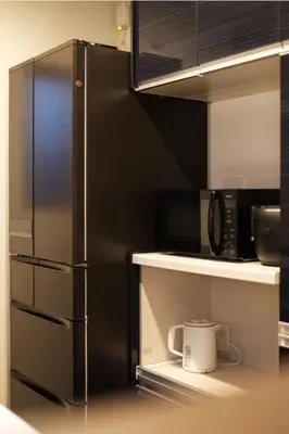 a kitchen with a black refrigerator and a microwave at japan house \u30f4\u30a3\u30e9\u8cb8\u5207\u6771\u5411\u5cf6\u99c55\u5206\u30b9\u30ab\u30a4\u30c4\u30ea\u30fc\u8fd1\u304f\u4e09\u53f7\u9928 in Tokyo
