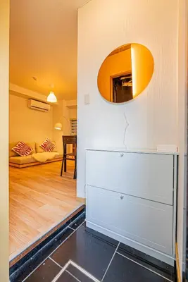 a living room with a white dresser and a mirror at Aurora1 in Tokyo