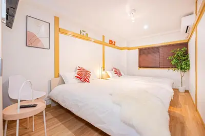 a bedroom with two beds and a table and a chair at Aurora1 in Tokyo