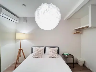 a bedroom with a white bed and a lamp at Higashinakano House NN0021 in Tokyo