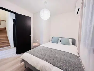a white bedroom with a large bed with blue pillows at Higashinakano House NN0021 in Tokyo
