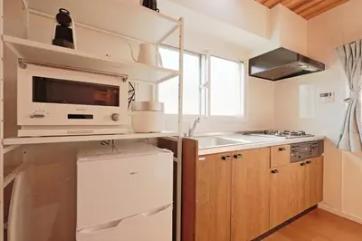 a kitchen with a white refrigerator and a microwave at V Close to Shinjuku Kabukicho Korean Town FrWIFI J in Tokyo