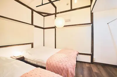 a bedroom with two beds and a large window at \u548c\u6c23\u4f1a\u3005\u66f3\u821f Wakiaiai Hikihune in Tokyo
