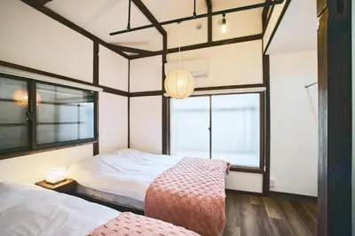 a bedroom with two beds and a large window at \u548c\u6c23\u4f1a\u3005\u66f3\u821f Wakiaiai Hikihune in Tokyo