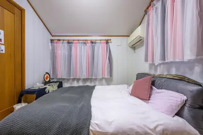 a small bedroom with a bed with pink pillows at Nakano Shinjuku Sapphire Single-family House in Tokyo