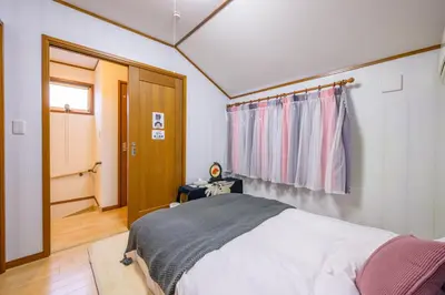 a bedroom with a bed and a window and a door at Nakano Shinjuku Sapphire Single-family House in Tokyo