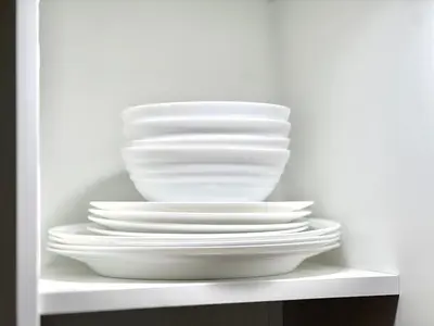 a stack of white plates sitting on a shelf at shinjuku yichun hostel-SJ0399 in Tokyo
