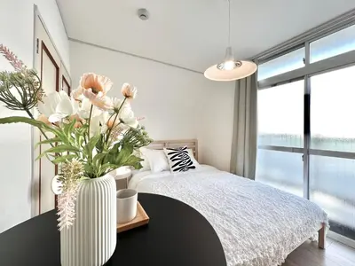 a bedroom with a bed and a vase with flowers at shinjuku yichun hostel-SJ0399 in Tokyo