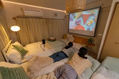 two girls laying on couches in a living room watching a screen at Stay in the most popular city for young people in Japan in Tokyo