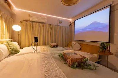 a room with two beds and a large screen at Stay in the most popular city for young people in Japan in Tokyo