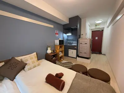 a bedroom with a bed and a kitchen at Bali Haven Yotsuya \u30d0\u30ea\u306e\u96a0\u308c\u5bb6 \u56db\u8c37\u99c5\u5f92\u6b697\u5206\u30c0\u30d6\u30eb\u30d9\u30c3\u30c81R in Tokyo