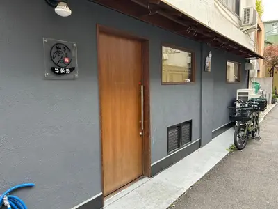 a building with a door and a bike parked outside at Bali Haven Yotsuya \u30d0\u30ea\u306e\u96a0\u308c\u5bb6 \u56db\u8c37\u99c5\u5f92\u6b697\u5206\u30c0\u30d6\u30eb\u30d9\u30c3\u30c81R in Tokyo