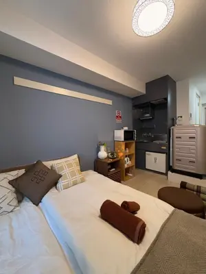 a large white bed in a room with a kitchen at Bali Haven Yotsuya \u30d0\u30ea\u306e\u96a0\u308c\u5bb6 \u56db\u8c37\u99c5\u5f92\u6b697\u5206\u30c0\u30d6\u30eb\u30d9\u30c3\u30c81R in Tokyo