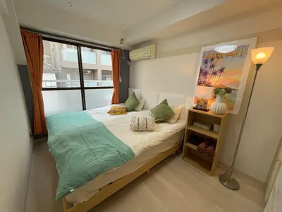 a small bedroom with a bed with a large window at Shinjuku Yotsuya Sanchome Station 7-minute walk Hawaiian Twin Bed Charm Room 1R in Tokyo