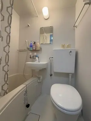 a white bathroom with a toilet and a sink at Shinjuku Yotsuya Sanchome Station 7-minute walk Hawaiian Twin Bed Charm Room 1R in Tokyo