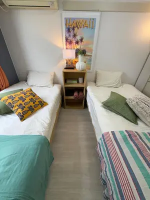 two beds sitting next to each other in a room at Shinjuku Yotsuya Sanchome Station 7-minute walk Hawaiian Twin Bed Charm Room 1R in Tokyo