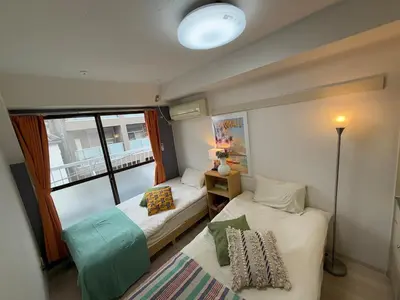 a small room with two beds and a window at Shinjuku Yotsuya Sanchome Station 7-minute walk Hawaiian Twin Bed Charm Room 1R in Tokyo