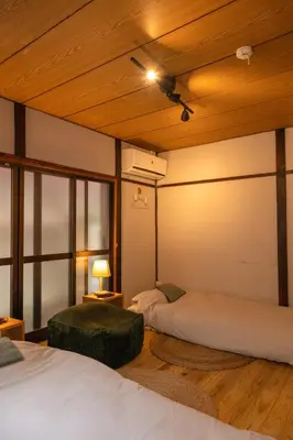 two beds in a room with wooden ceilings at Roopt\u795e\u697d\u5742 in Tokyo