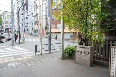 an empty city street with a tree and a fence at Roopt\u795e\u697d\u5742 in Tokyo