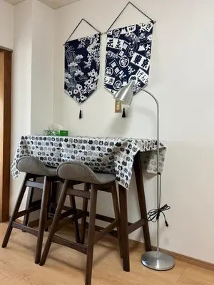 a table with a lamp and two umbrellas on a wall at \u4e0a\u91ce\u5708\u5f92\u6b65\u516c\u5bd3\u578b\u9152\u5e97 \u4e0b\u8c37\u99c5\u304b\u3089\u5f92\u6b653\u5206 in Tokyo