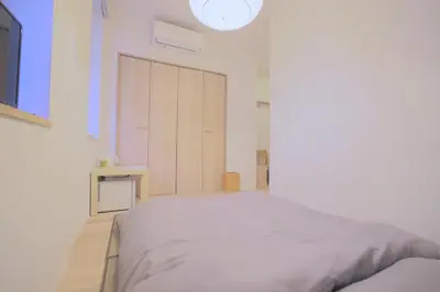 a white bedroom with a large bed and a closet at Kyo-wa Hotel in Tokyo