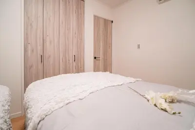 a bedroom with a white bed with a wooden door at \u5168\u65b0\u4e09\u4e4b\u8f6e\u4e00\u6237\u5efab\u680b in Tokyo