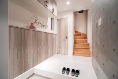 a hallway with a staircase and two pairs of shoes on the floor at \u5168\u65b0\u4e09\u4e4b\u8f6e\u4e00\u6237\u5efab\u680b in Tokyo