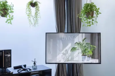 a flat screen tv sitting in a room with potted plants at Natsumezaka Room1 NM1 in Tokyo