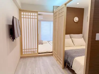a small bedroom with a bed and a mirror at Shibuya\u73b0\u4ee3\u548c\u5f0f\u98ce\u683c-\u6e0b\u8c37\u5f92\u6b654min-\u65b0\u5bbf\u516d\u672c\u6728\u4e0a\u91ce\u76f4\u8fbe-New Open Max6P in Tokyo