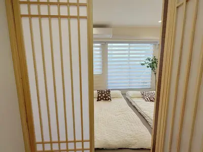 an open door to a room with a bed and a window at Shibuya\u73b0\u4ee3\u548c\u5f0f\u98ce\u683c-\u6e0b\u8c37\u5f92\u6b654min-\u65b0\u5bbf\u516d\u672c\u6728\u4e0a\u91ce\u76f4\u8fbe-New Open Max6P in Tokyo