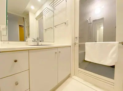 a white bathroom with a shower and a sink at Pangoo Shinagawa Room 101 - Vacation STAY 93916v in Tokyo