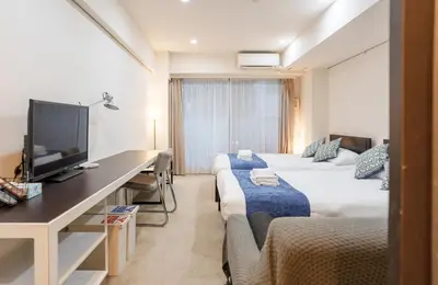 a room with two beds and a desk with a television at Pangoo Shinagawa Room 102 - Vacation STAY 97700v in Tokyo