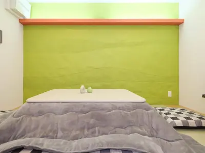 a bedroom with a bed with a green wall at HOTEL \u5fc3 asakusa in Tokyo