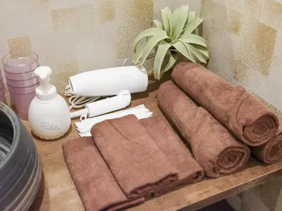 a table topped with towels and a hair dryer and a table with at HOTEL \u5fc3 asakusa in Tokyo