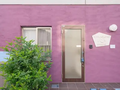 a purple house with a door with a sign on it at HOTEL \u5fc3 asakusa in Tokyo