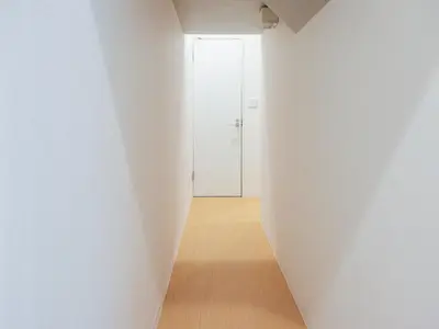 a hallway with a white wall and a door at HOTEL \u5fc3 asakusa in Tokyo
