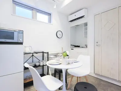 a white kitchen with a white table and chairs at HOTEL \u5fc3 asakusa in Tokyo