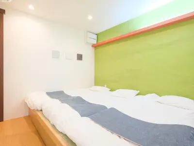 a large bed in a room with a green wall at HOTEL \u5fc3 asakusa in Tokyo