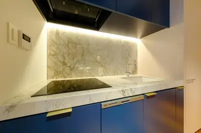 a kitchen with blue cabinets and a marble counter top at Roppongi House by U - Designers room - Steps to Roppongi Hills & Nightlife in Tokyo