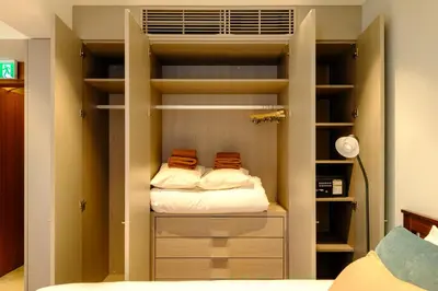 a bedroom with a closet with two beds at Roppongi House by U - Designers room - Steps to Roppongi Hills & Nightlife in Tokyo
