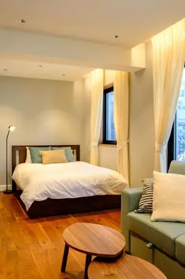 a bedroom with a bed and a couch at Roppongi House by U - Designers room - Steps to Roppongi Hills & Nightlife in Tokyo