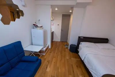 a bedroom with a bed and a blue chair at YIYou Japan\u79cb\u8449\u539f301 in Tokyo