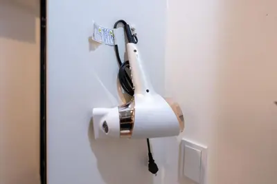 a hair dryer is hanging on a wall at YIYou Japan\u79cb\u8449\u539f301 in Tokyo