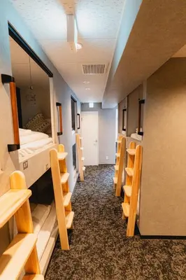 a room with rows of chairs and a bed at Guesthouse Akasaka in Tokyo