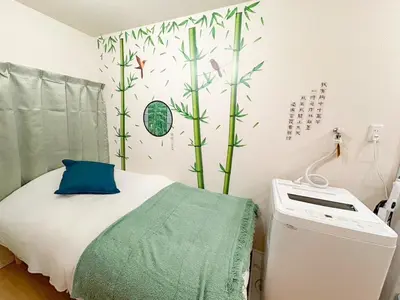 a bedroom with a bed with green plants on the wall at B 3rooms MAX10people 6min Shinjuku 11min Shibuya 12min walk Ikebukuro LEON RESORT IKEBUKURO traditional Japanese room \u6c60\u888b \u6700\u592710\u540d in Tokyo