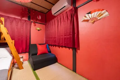 a room with red walls and a bed and a chair at B 3rooms MAX10people 6min Shinjuku 11min Shibuya 12min walk Ikebukuro LEON RESORT IKEBUKURO traditional Japanese room \u6c60\u888b \u6700\u592710\u540d in Tokyo