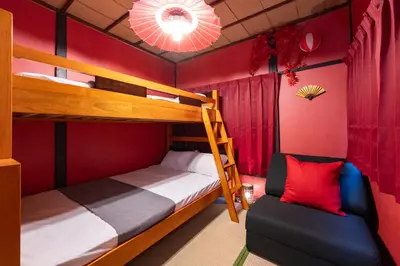 a bedroom with two bunk beds and a chair at B 3rooms MAX10people 6min Shinjuku 11min Shibuya 12min walk Ikebukuro LEON RESORT IKEBUKURO traditional Japanese room \u6c60\u888b \u6700\u592710\u540d in Tokyo
