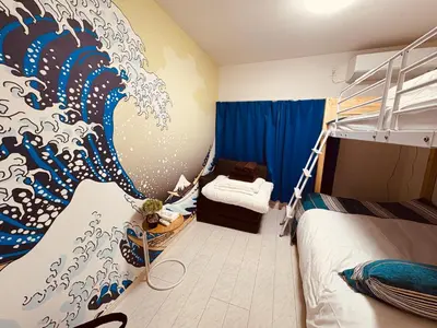 a bedroom with a mural of a wave on the wall at B 3rooms MAX10people 6min Shinjuku 11min Shibuya 12min walk Ikebukuro LEON RESORT IKEBUKURO traditional Japanese room \u6c60\u888b \u6700\u592710\u540d in Tokyo